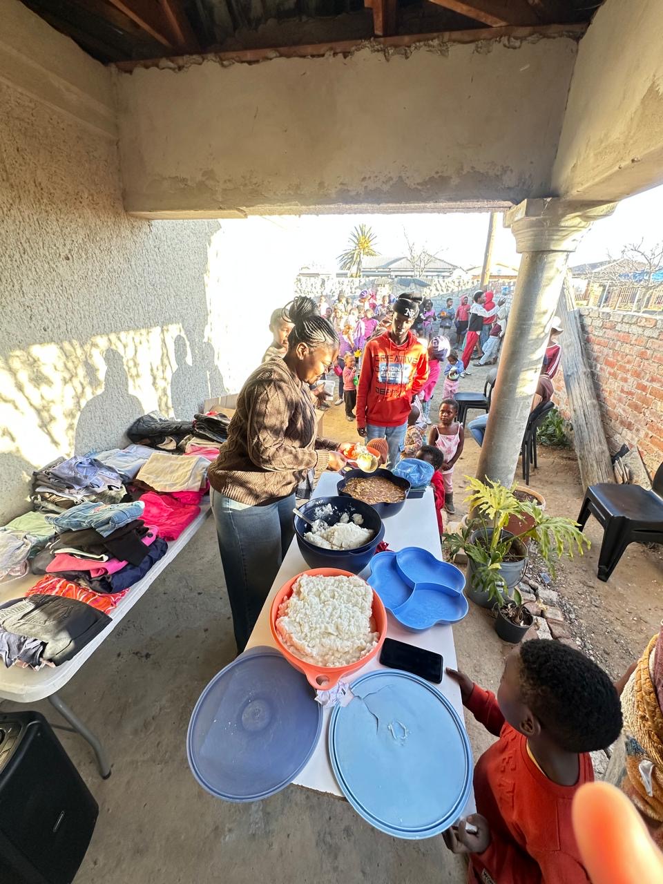 Volunteers dishing up warm meals and laying out donated clothing for families